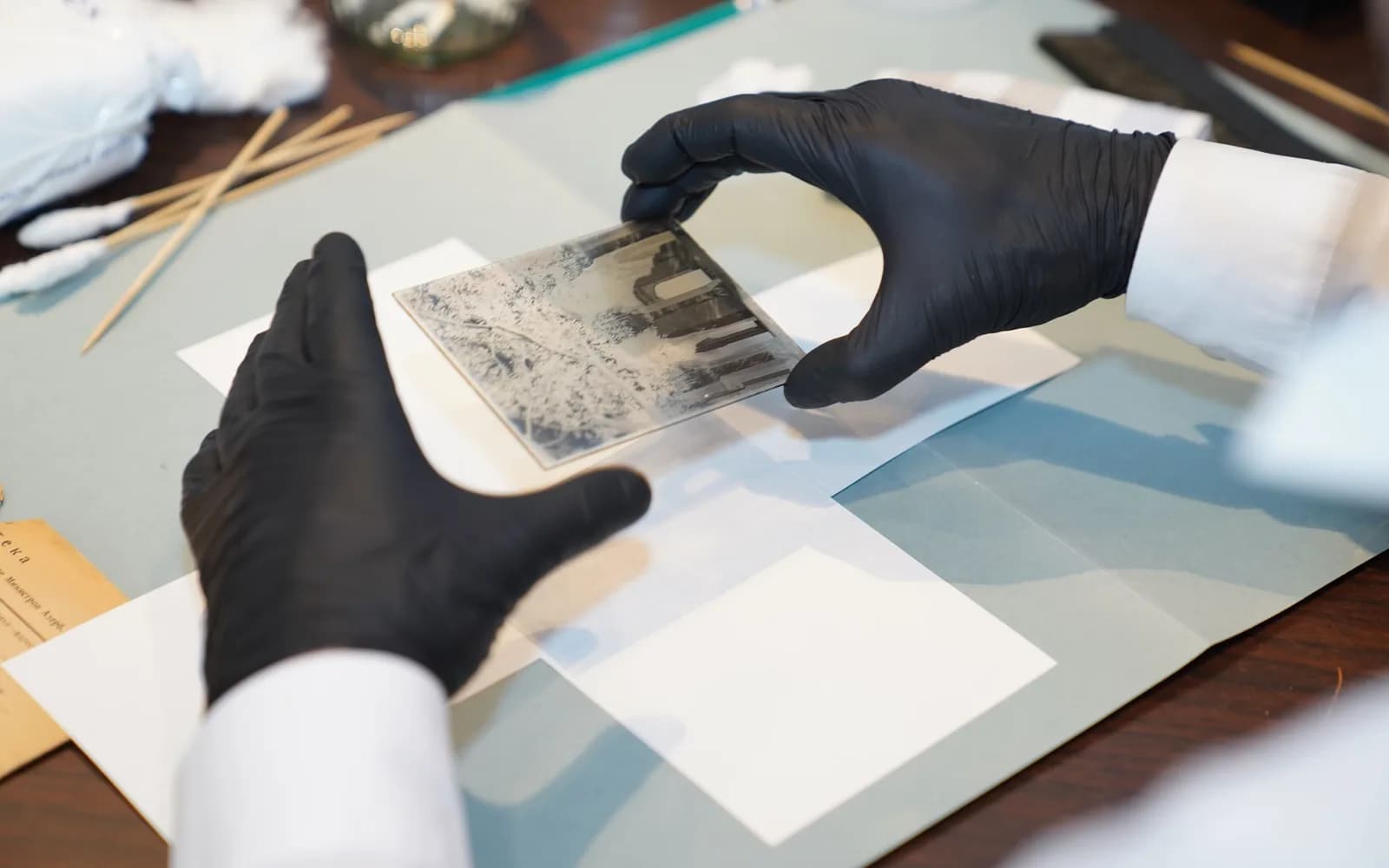 Conservator wearing gloves while restoring a historic photograph